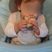Olivia, avec les deux mains, mange sa brioche